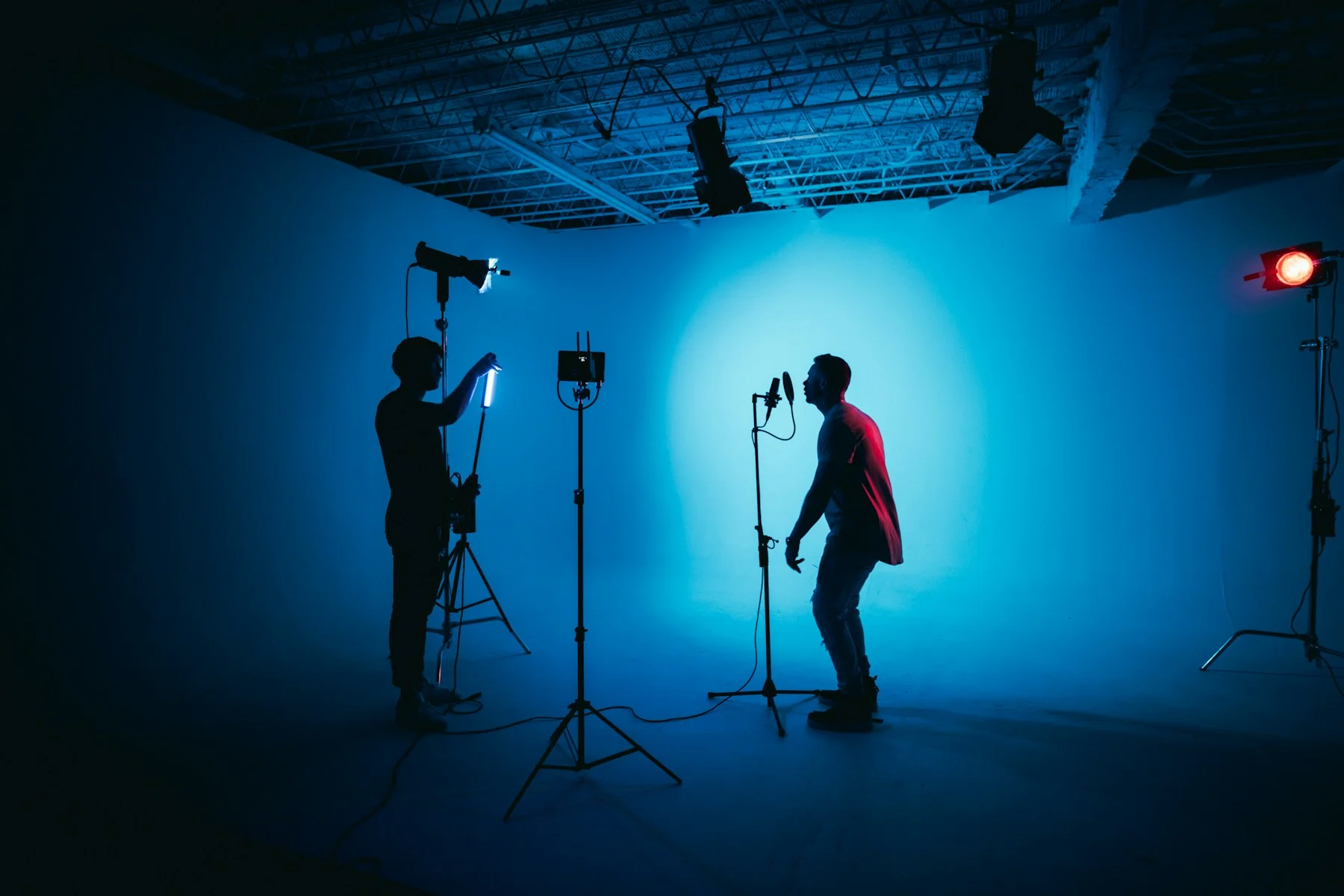 Filmmakers creating a video together in a blue-lit production studio